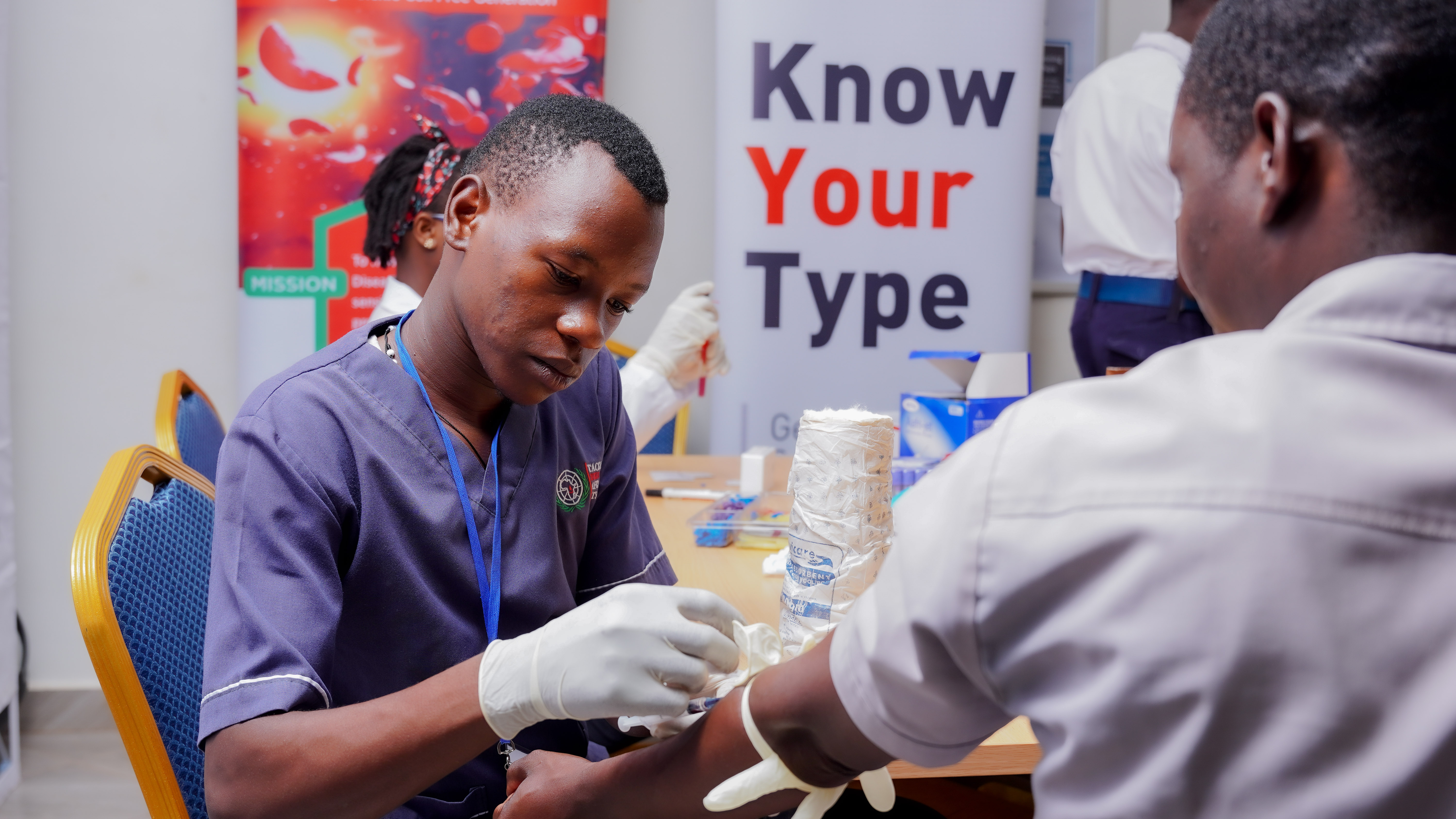 Youth leaders and volunteers engaged in sickle cell sensitization at an event.